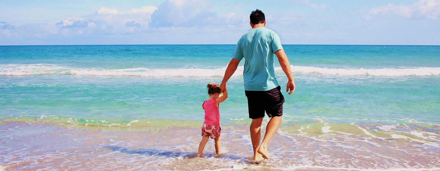 imagen de padre caminando con su hija pequeña en la playa tranquilos por tener un seguro de vida